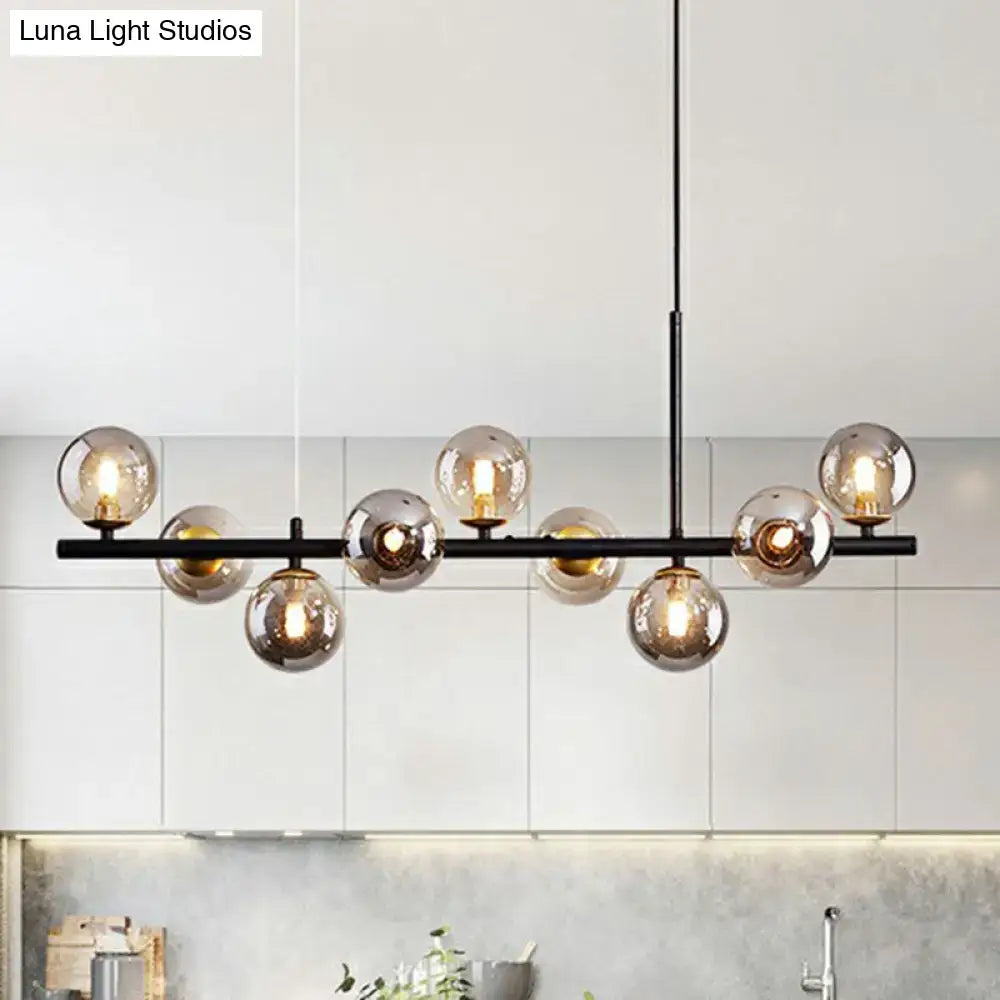 Modern black metal chandelier with multiple amber-tinted glass globes in smoke grey cognac for dining room lighting