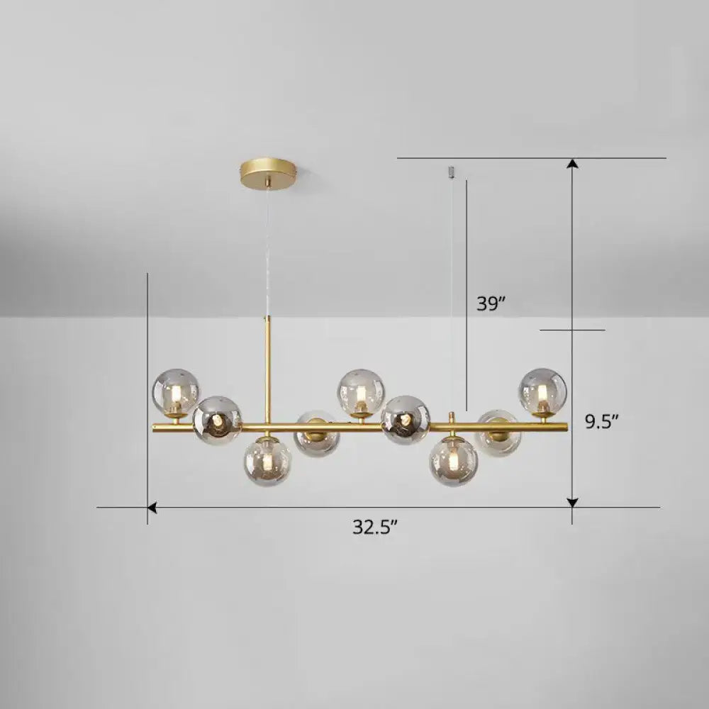 Modern brass chandelier with multiple frosted glass globe bulbs in clear smoke grey for dining room lighting