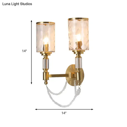 Postmodern water glass brass wall light with gold-toned sconce, two textured glass shades, and crystal chain detail