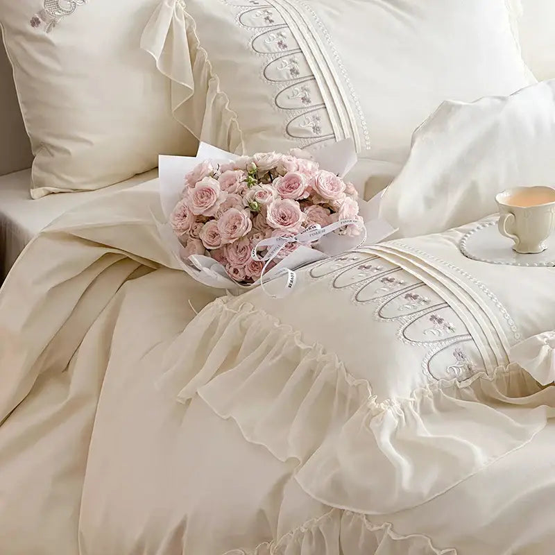 A delicate bouquet of soft pink roses complements the cream princess wedding bedding set with decorbites flowers embroidery