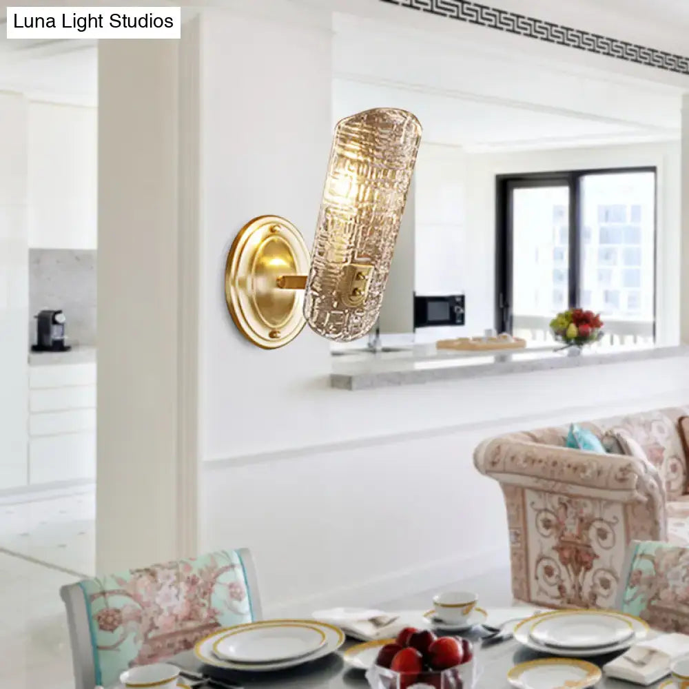 Gold-toned wall light with a textured translucent prism glass shade designed for corridor lighting