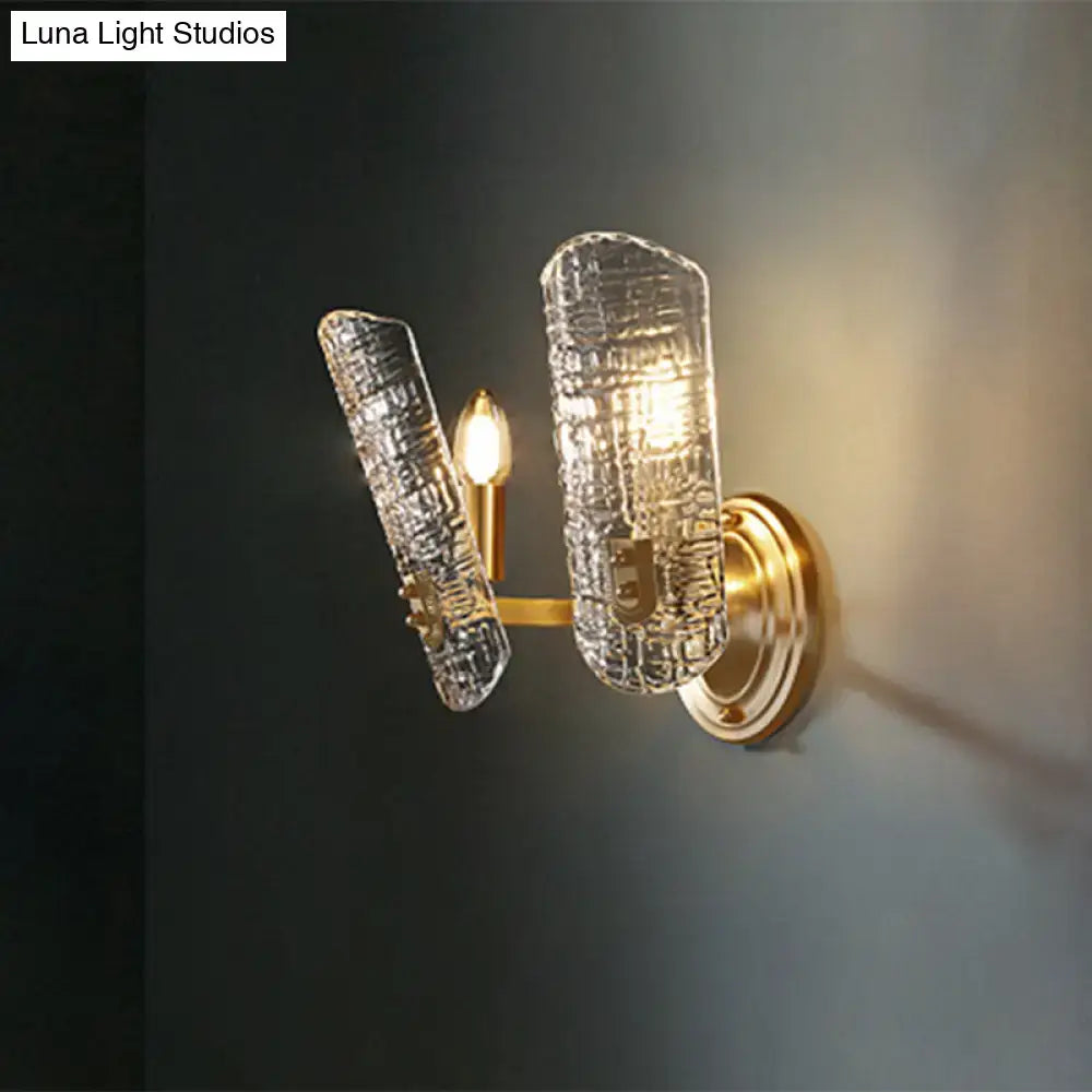 Gold-toned wall light with two clear textured glass shades featuring a crackled prism design for corridor use