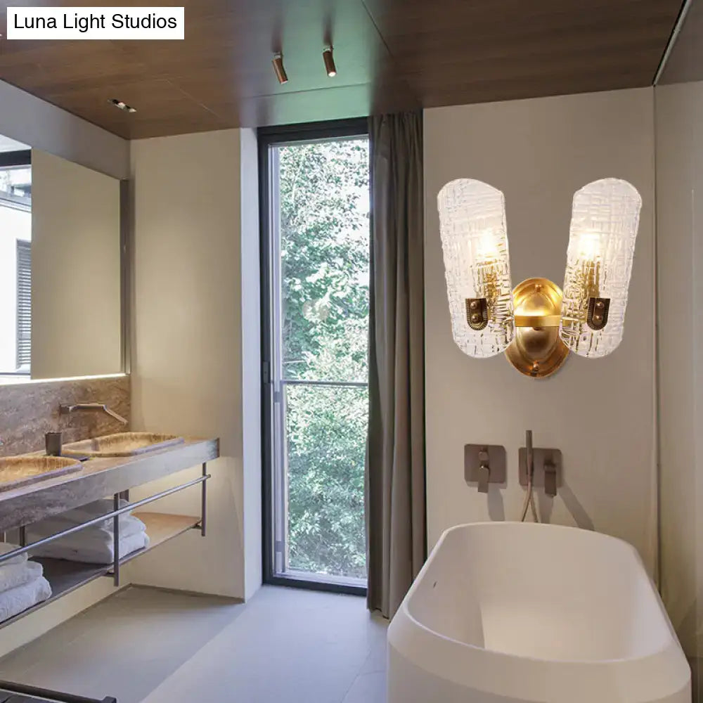 Gold-toned wall light with two textured frosted glass shades designed for corridor lighting