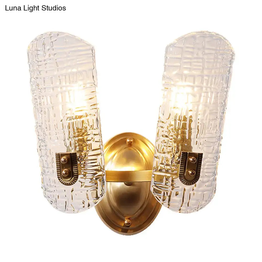 Gold-toned wall light with two textured clear glass shades featuring a woven pattern ideal for corridor lighting