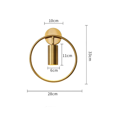 gold-toned circular wall lamp with cylindrical central element and mounting plate in the modern black and gold irwin wall lamp for bedroom sconce design.