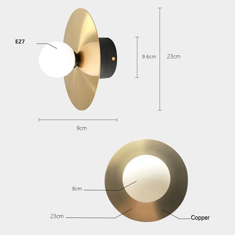 A modern riya wall light with a brushed copper circular base, white frosted glass spherical bulb, and e27 socket suitable for bedroom use.
