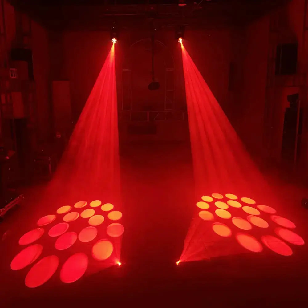 Two red 150w mini led moving head stage lights cast dramatic beams and circular spotlights in a dark room for disco use