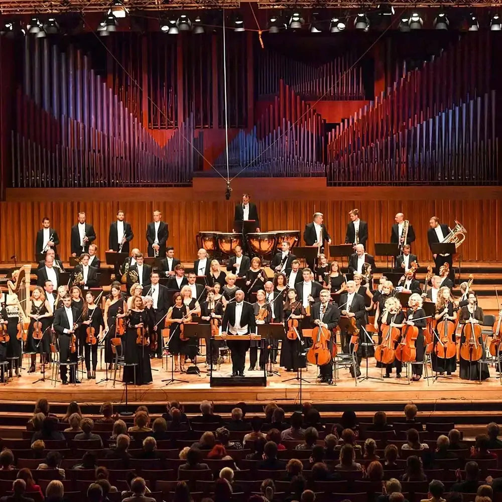 A full symphony orchestra performing under a professional black decorbites big dipper stage light with warm and cold white lighting