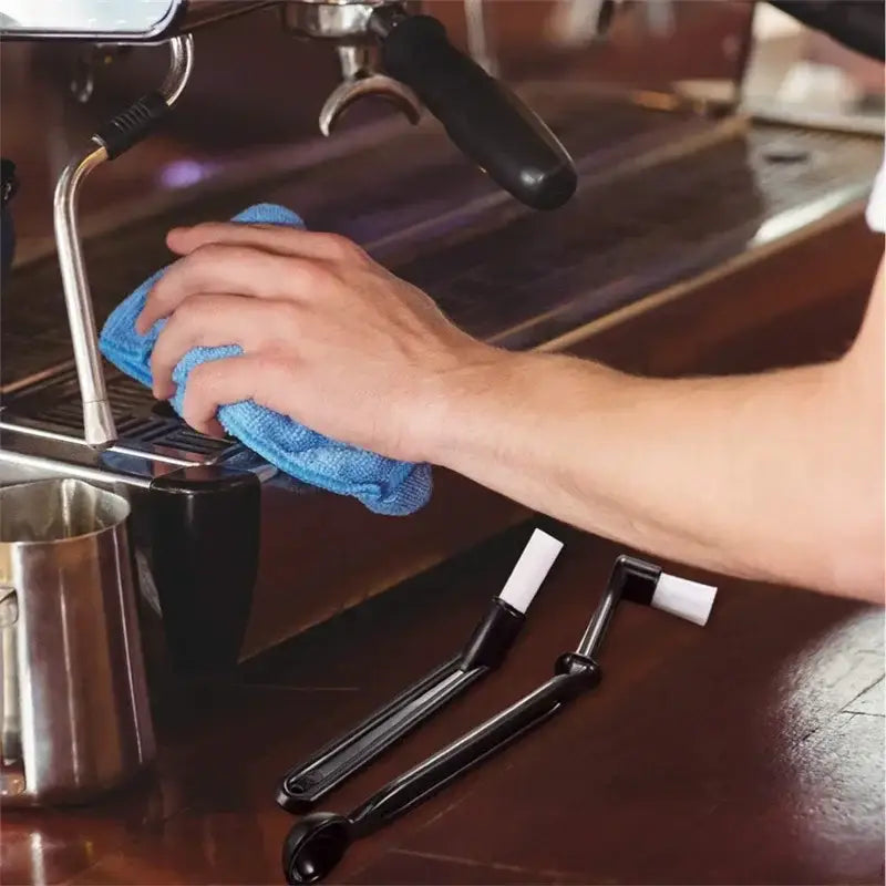 Blue microfiber cloth from professional coffee machine cleaning brush set wiping down espresso machine surface