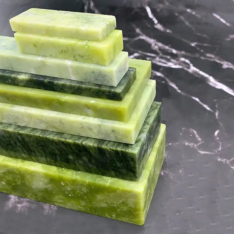 Stack of polished green jade blocks in varying shades for professional green stone kitchen knife sharpener set decorbites