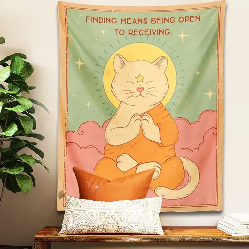 Soft green and pink decorbites cat tapestry featuring an orange robe cat meditating under a yellow tapestry sun moon