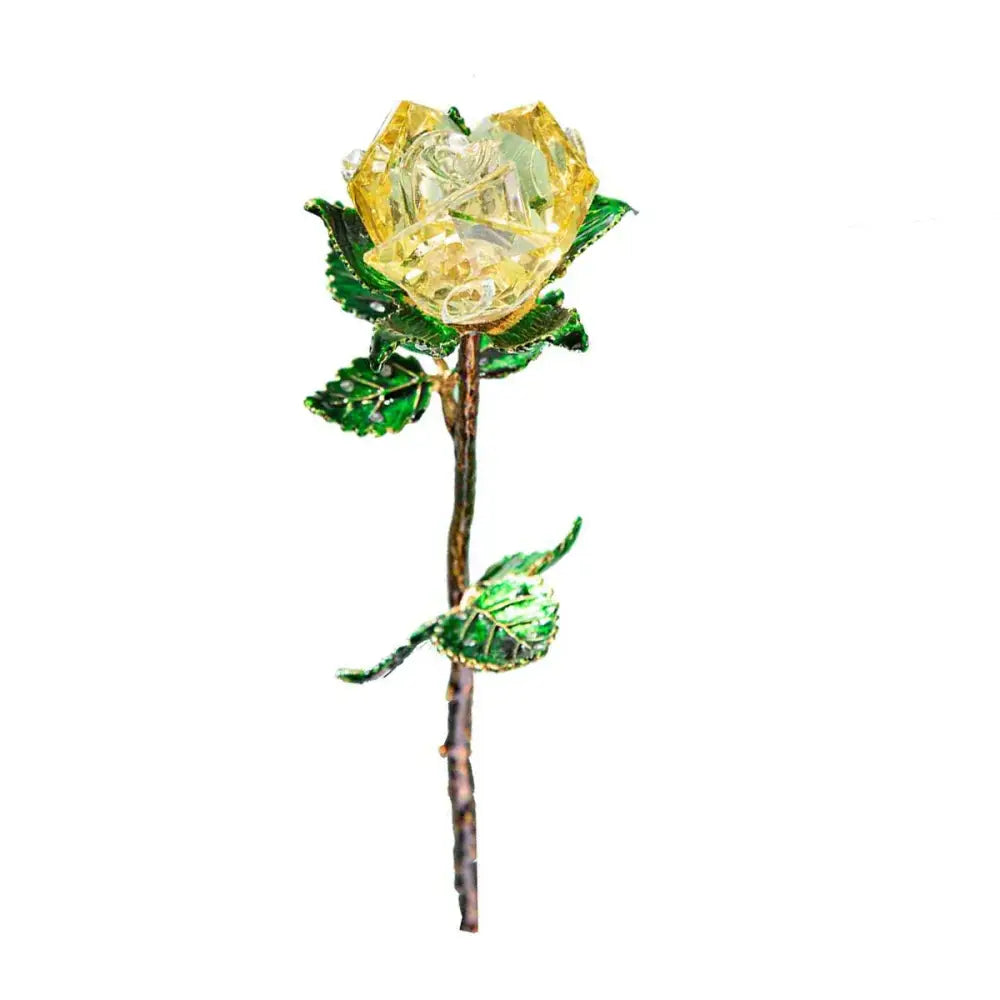 A delicate yellow crystal rose figurine brooch with green enamel leaves and metallic stem for elegant décor