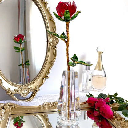 A sparkling red and gold crystal rose figurine with green leaves displayed in a clear crystal vase for living room decor