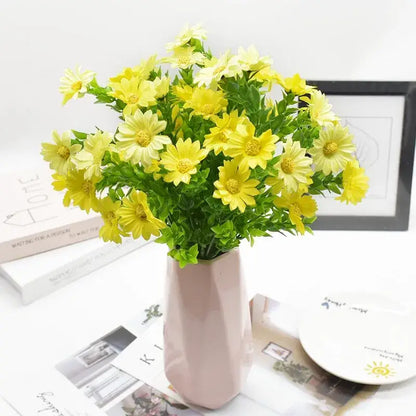 A purple and yellow daisy bouquet green plant synthetic flowers arranged in a pink geometric vase for living room