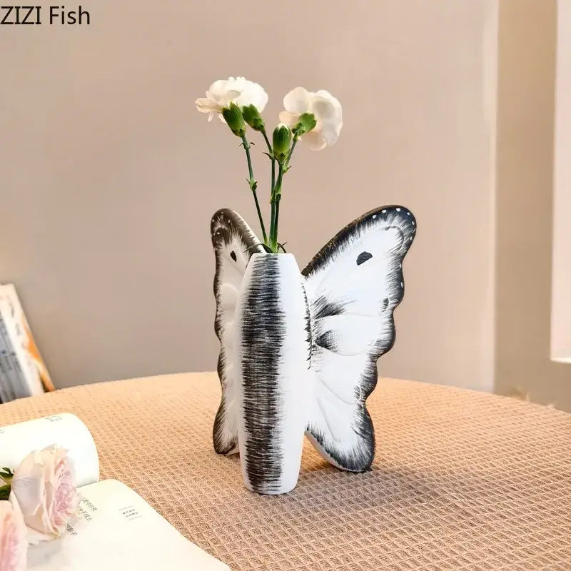 White ceramic dark butterfly vase with black brushstroke detailing and white flowers for decorbites dark butterfly decor