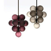 Two modern decorbites grape chandelier pendant lights in deep purple and muted gray with ribbed glass bulbs