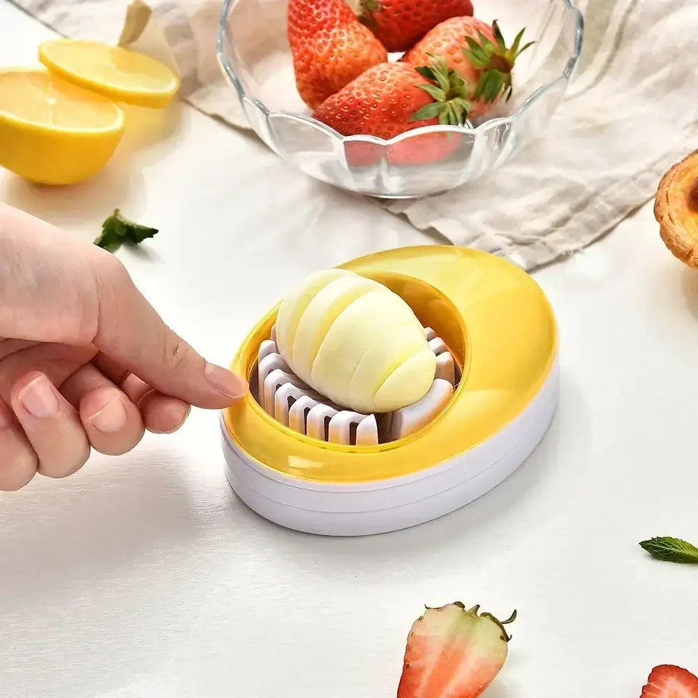 Yellow and white egg cutter slicer with curved oval design and purple rotating blade for kitchen use