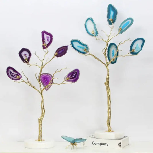 Two decorative purple and teal golden agate tree art piece sculptures with gold-toned branches on marble bases