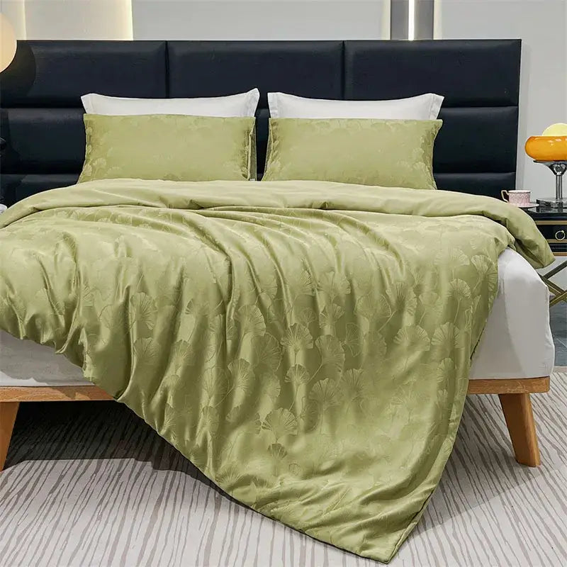 Soft sage green satin duvet cover set with subtle embossed ginkgo leaf pattern for luxury bedroom use