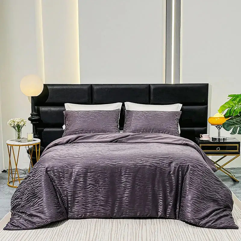 Purple zebra print satin duvet cover set with subtle wavy texture displayed on black upholstered bed for luxury bedroom