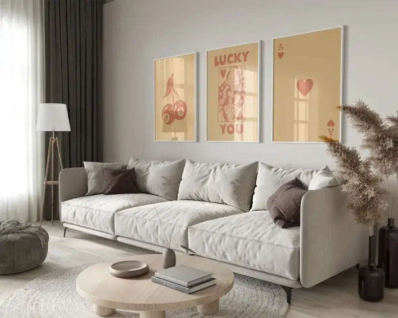 Light gray upholstered sectional sofa with dark brown throw pillows next to DecorBites™ 3-piece retro hearts wall art set