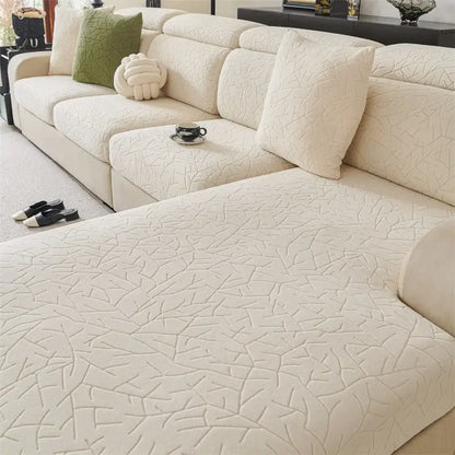 Cream-colored quilted sofa cover with subtle leaf pattern made of elastic fabric for living room use