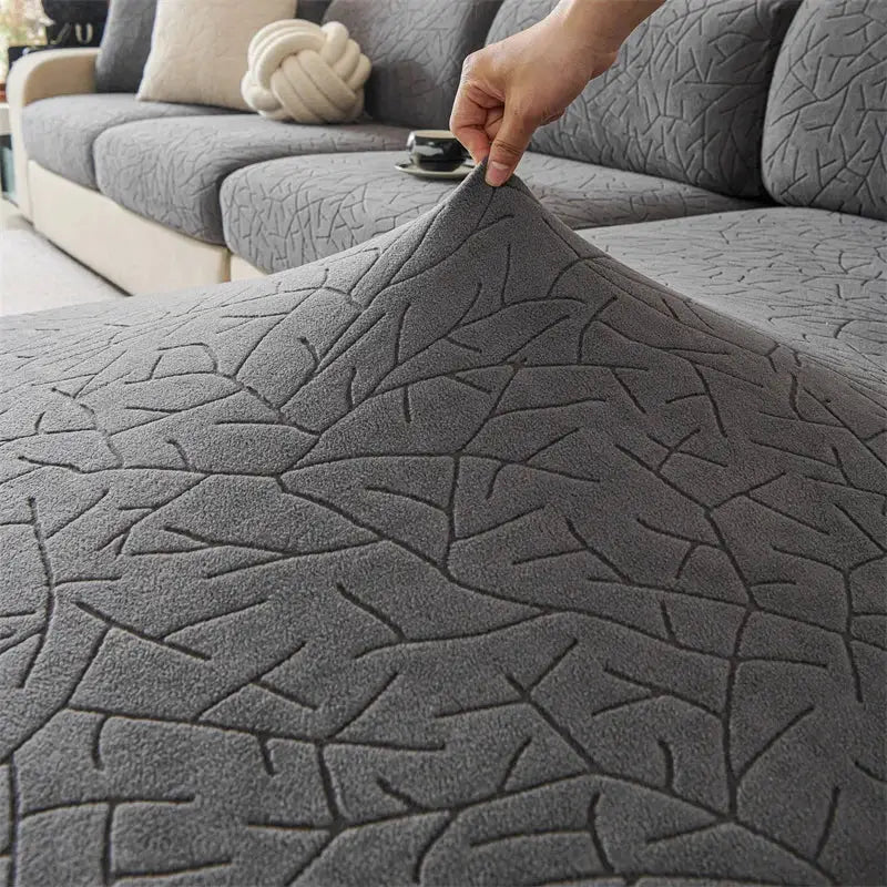 Gray textured sofa cover with a subtle leaf-like pattern.