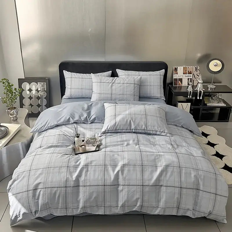 Light blue and gray plaid duvet cover set with matching pillowcases in a quilted cream and black geometric printed bed set