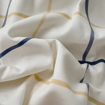 Quilted cream and black geometric printed bed set featuring soft white fabric with thin gold and navy blue stripes