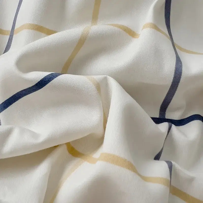 Quilted cream and black geometric printed bed set featuring soft white fabric with thin gold and navy blue stripes