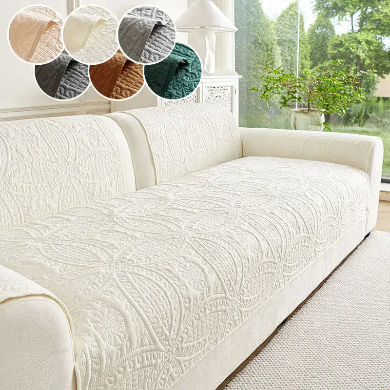 Cream-colored quilted sofa cover with intricate floral embroidery designed for living room cushions