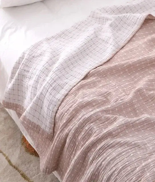 A soft textured muslin cotton summer blanket with a subtle pink and white checkered pattern from decorbites cotton summer collection