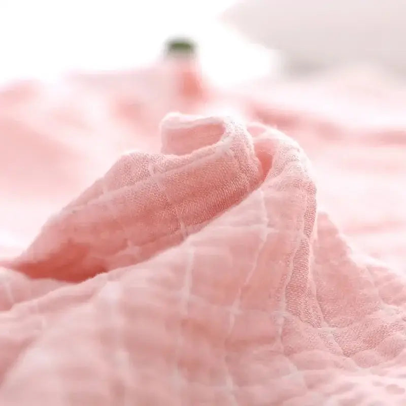 Soft pink cotton muslin cloth with subtle texture featured in quilted gray and blue decorbites cotton summer blanket