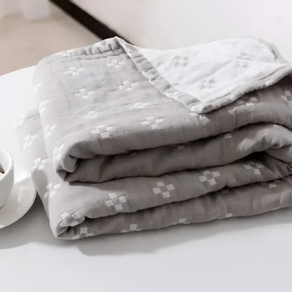 A soft gray quilted decorbites cotton summer blanket with subtle white crosshatch pattern for bedroom use