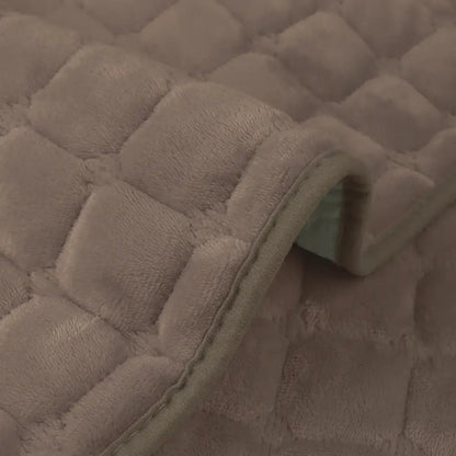 Beige quilted plush sofa cover with soft fuzzy texture and stitched edge for non slip living room use