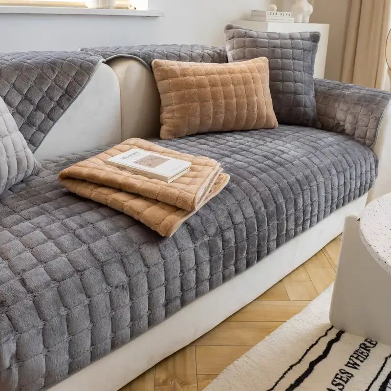Gray quilted faux fur sofa cover with a matching tan throw blanket and pillow.