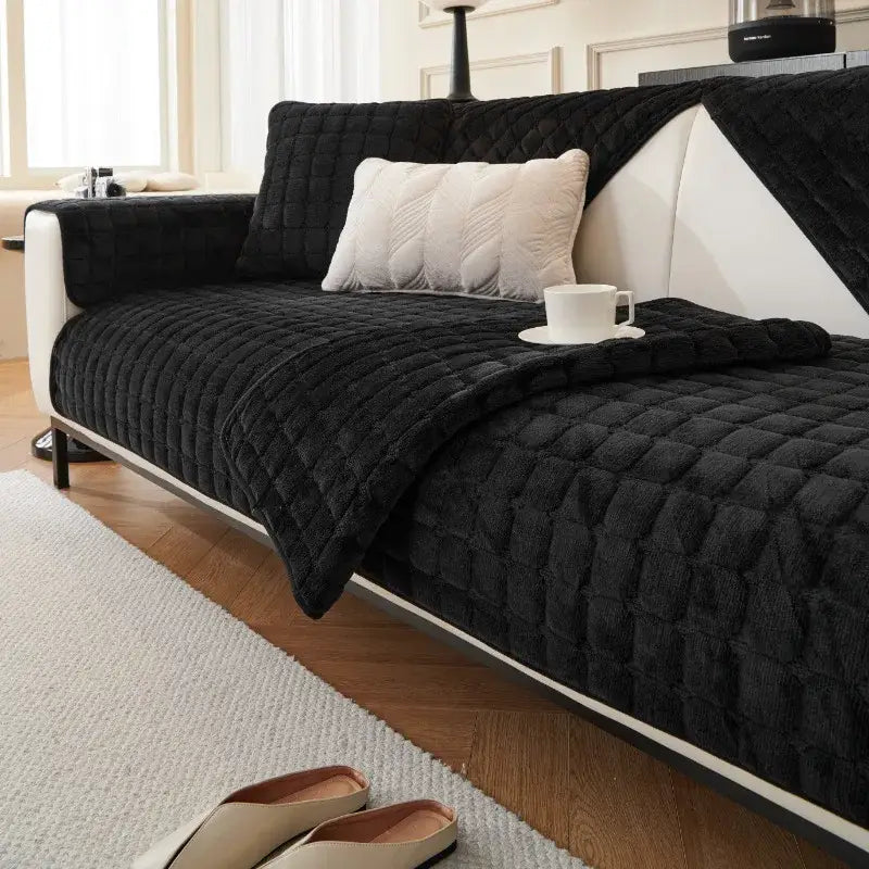 Black quilted velvet sofa cover with plush texture and white piping part of gray and tan faux fur living room set