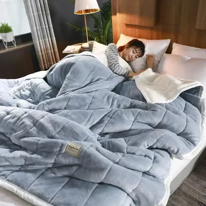 A cozy light blue quilted coral fleece blanket with white inner lining perfect for bedroom bedding decorbites cozy