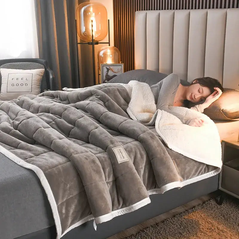Gray plush quilted bed blanket with cozy coral fleece lining and stitched diamond pattern for decorbites cozy coral use