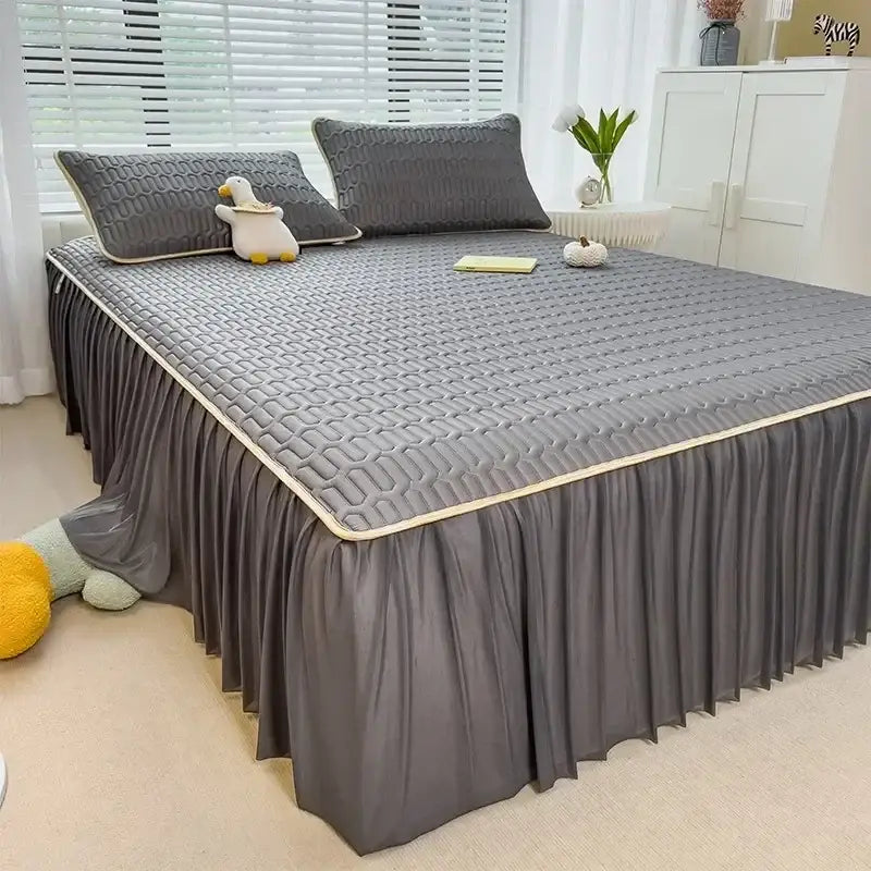 Gray quilted bed skirt set with pleated skirt and cream trim complementing a quilted pink bed skirt set with silver trim