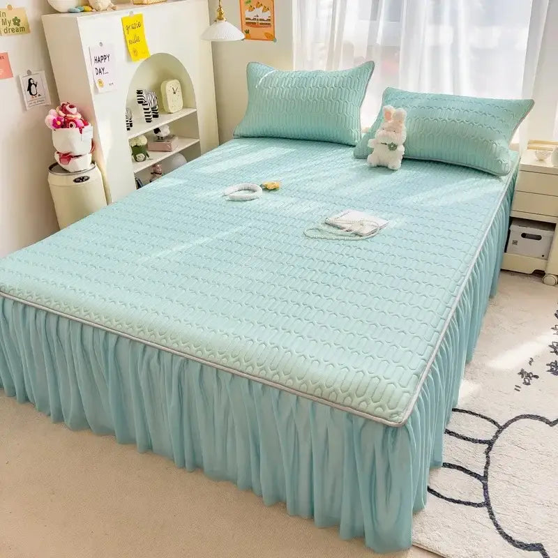 Mint green quilted bed skirt set with ruffled hem and matching pillowcases complements pink skirt set with silver trim