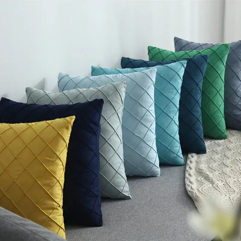 A collection of quilted velvet lattice cushion covers in yellow, navy blue, light gray, teal, and green for living rooms