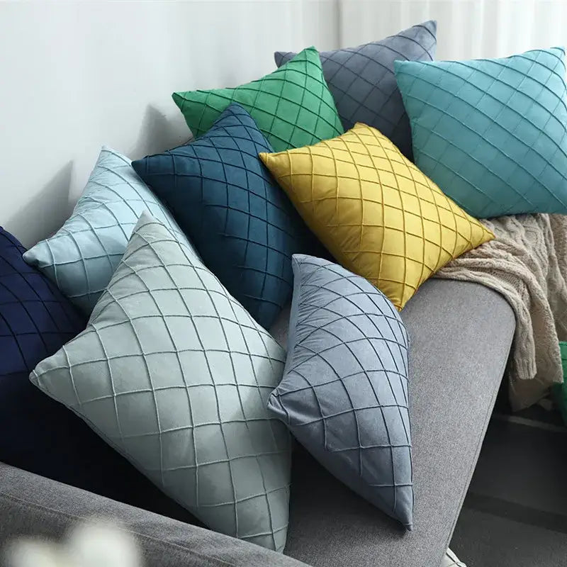 A collection of quilted velvet lattice cushion covers in teal yellow navy blue and gray for living room use