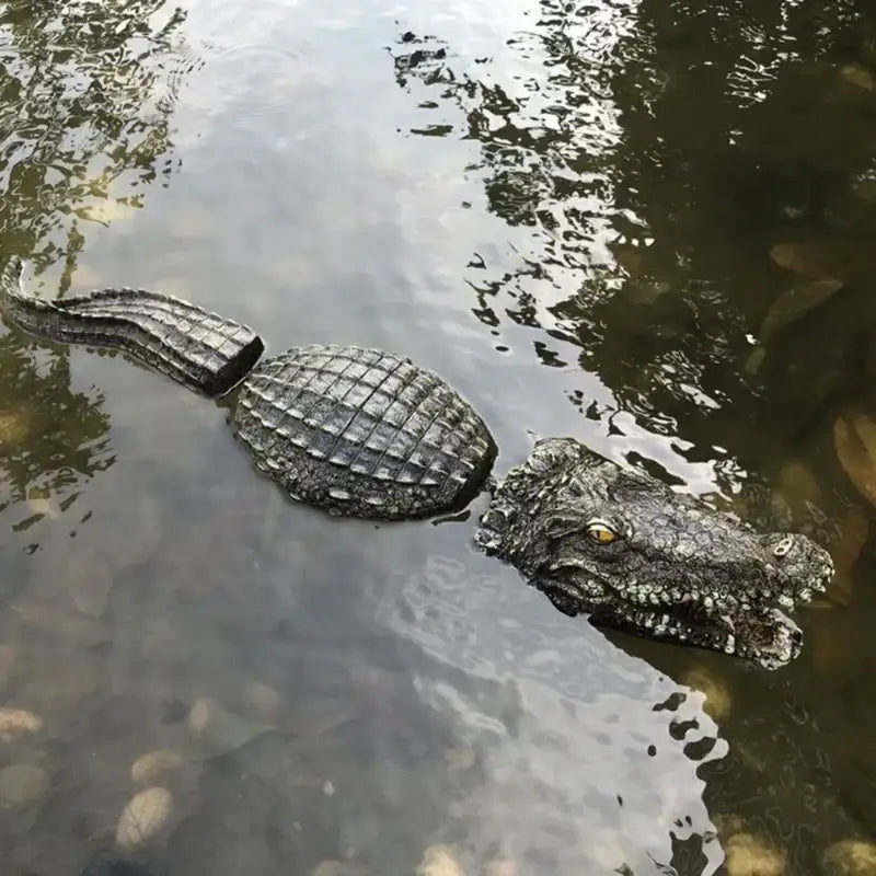Realistic dark gray plastic crocodile with textured scales partially submerged in water for decorbites garden water use