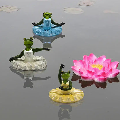 Three miniature frog figurines in ballet tutus with green and blue accents near a pink lotus flower for decorbites garden water floating