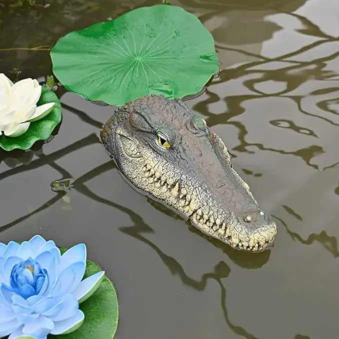 Realistic dark gray plastic crocodile head with yellow eyes floating among lily pads for decorbites garden water floating decor