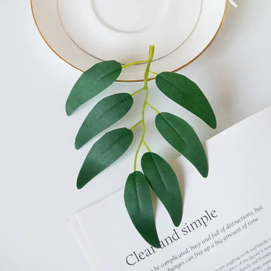 A delicate artificial silk willow sprig with glossy dark green willow leaves and a slender light green stem for decor