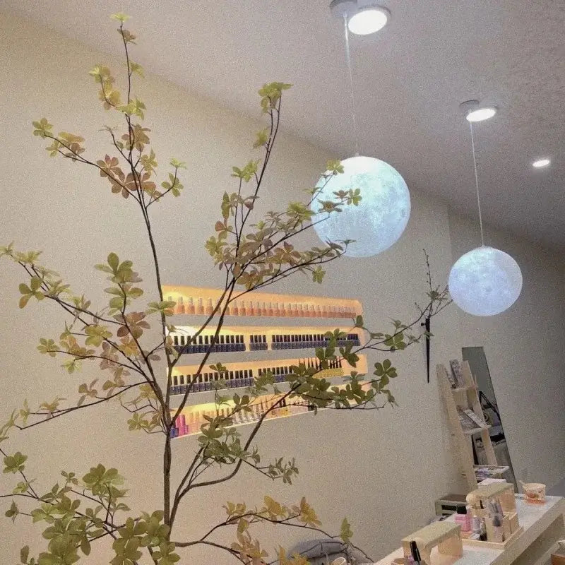 Two spherical white and yellow moon textured pendant lights made of high polymer hang from ceiling for bedroom use