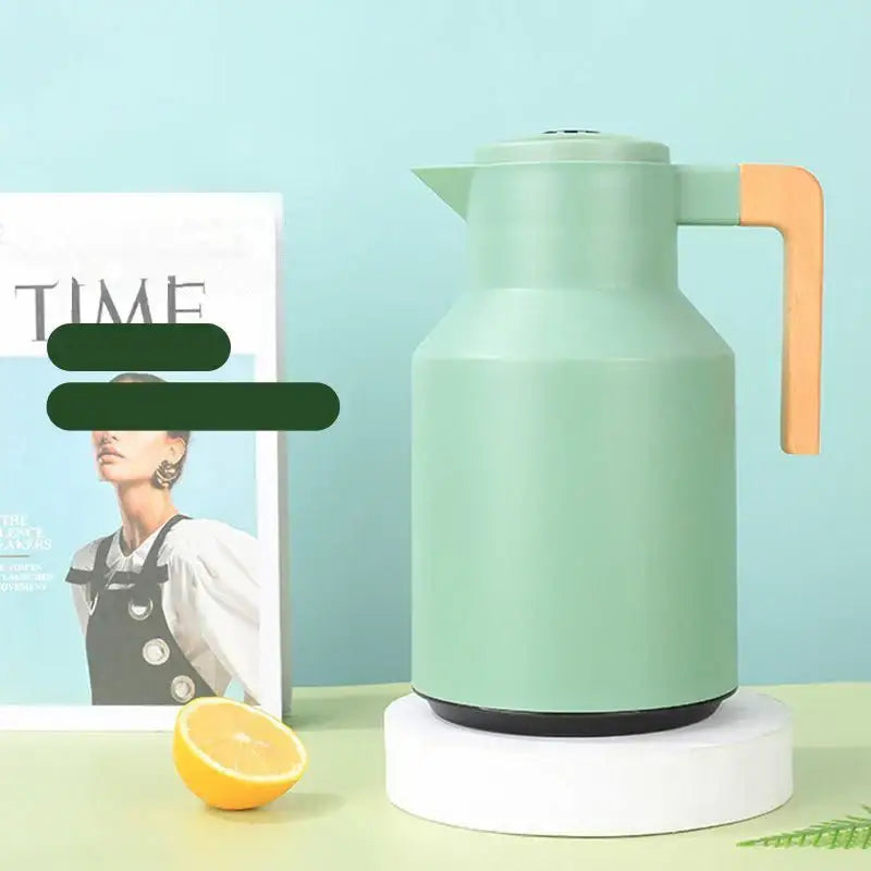 Mint green insulated water thermos kettle with orange wooden handle and black base for kitchen use