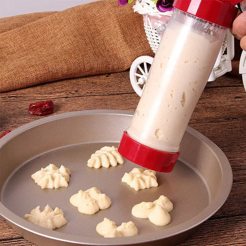 Red and silver cake cream decorating gun kit with red plastic cream decorating gun extruding light beige dough swirls